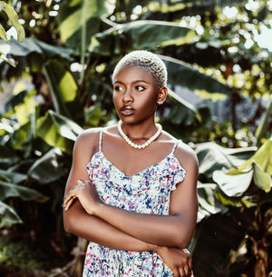 Woman in a floral dress standing among green plants
